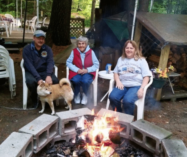Campers around the campfire with their dog